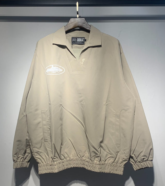 Buzo beige con cuello polo y emblema blanco — Corteiz