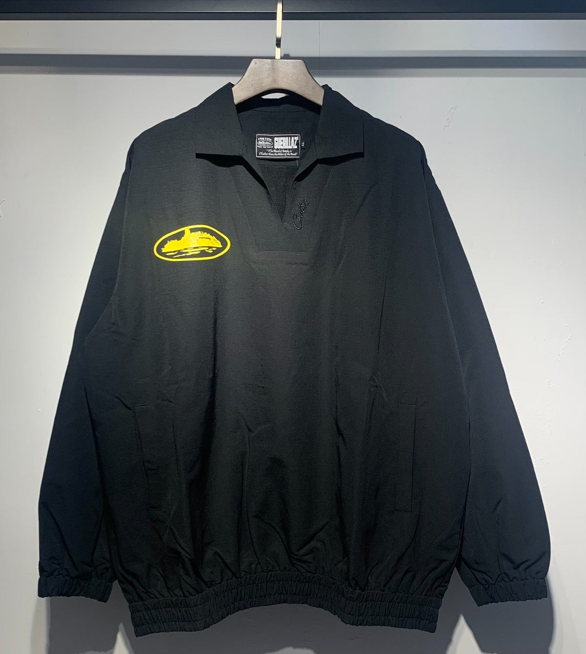 Buzo negro con cuello polo y emblema amarillo — Corteiz