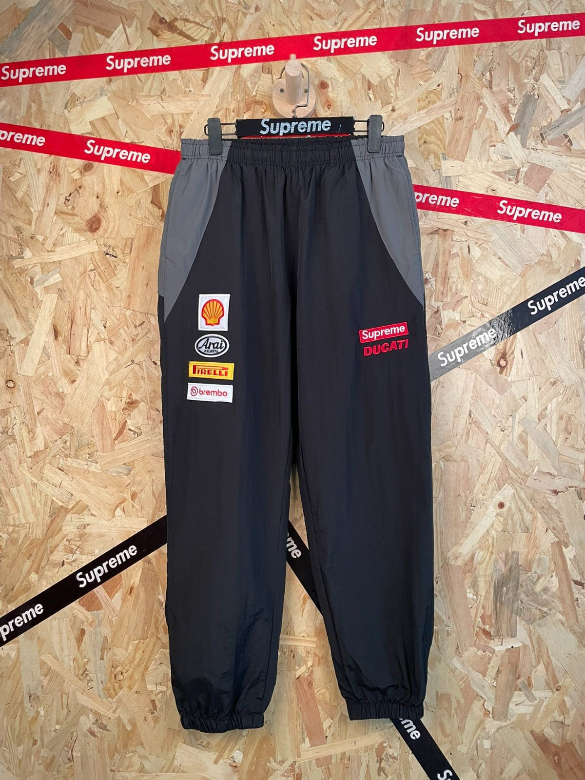 Pantalón deportivo negro con parches de carreras · Supreme — Supreme