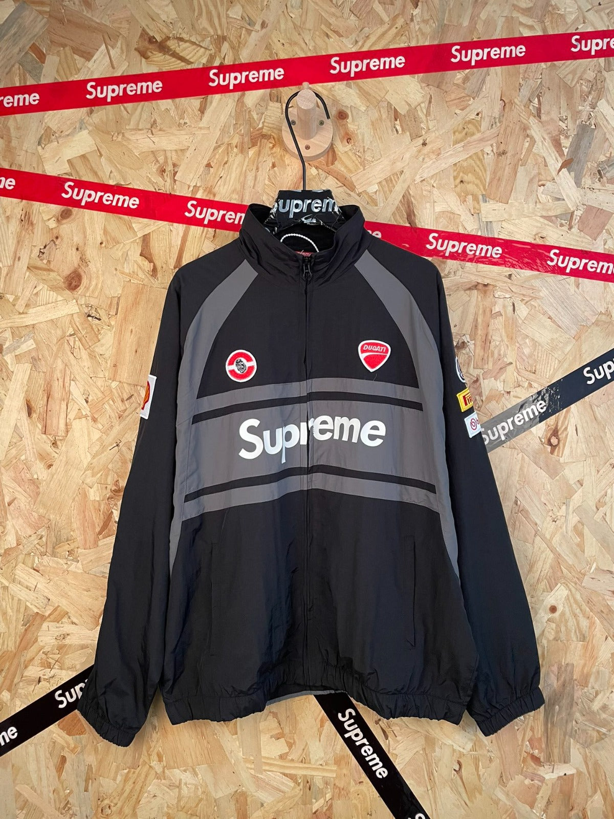 Campera negra con parches de carreras · Supreme — Supreme